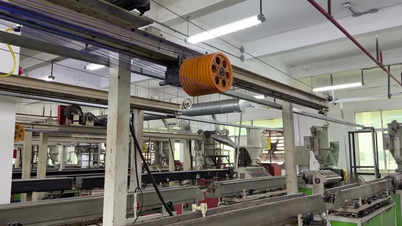 Wide view of the PLA extrusion lines with spool winding overhead